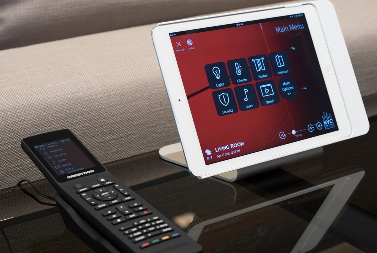 photo d'une tablette pour de la domotique avec une télécommande multifonctions à côté