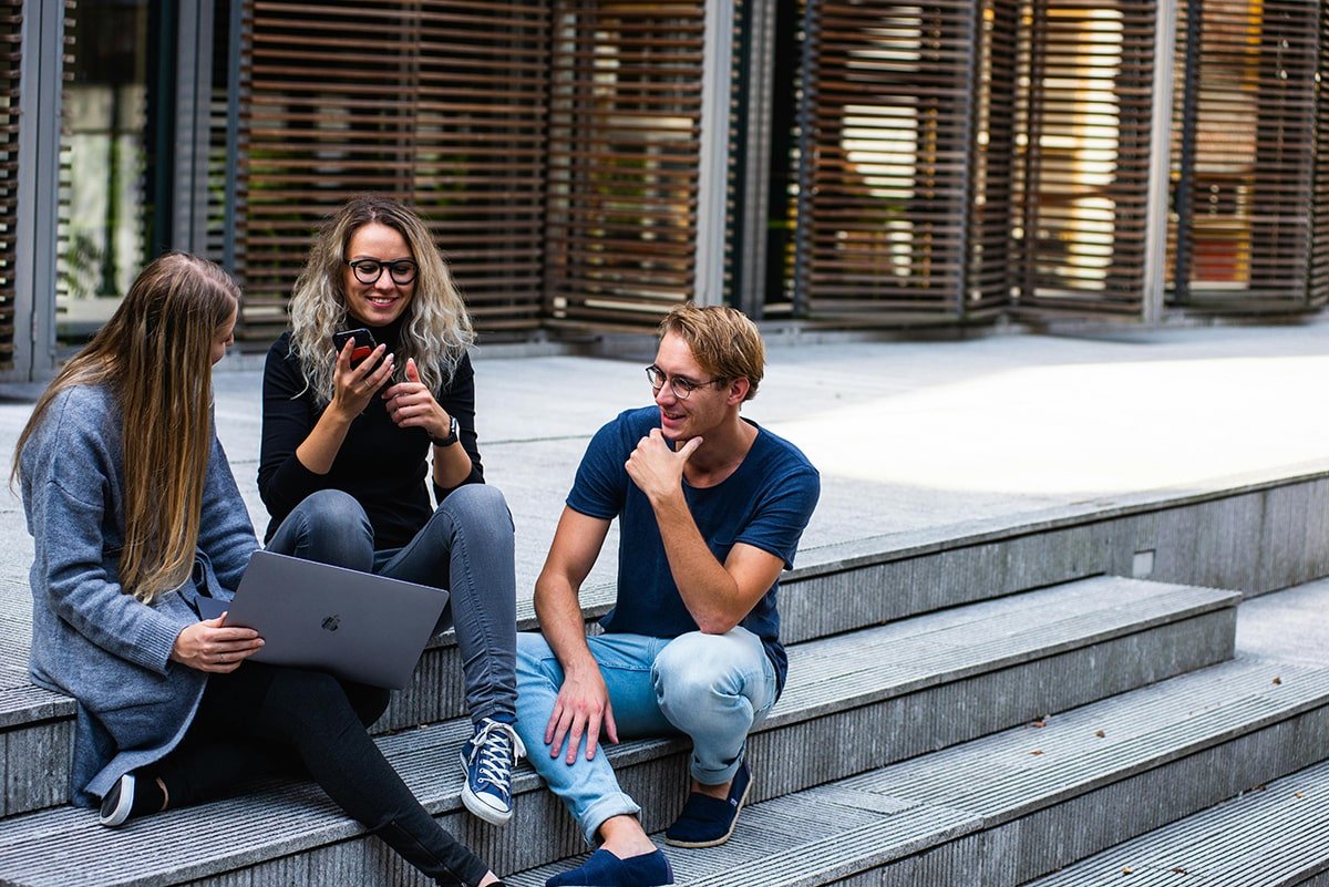 étudiant en gros plan qui tient un téléphone dans un campus universitaire